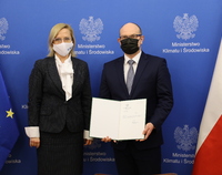 Minister Anna Moskwa oraz marszałek Artur Kosicki trzymający w ręku otwartą teczkę z dokumentem