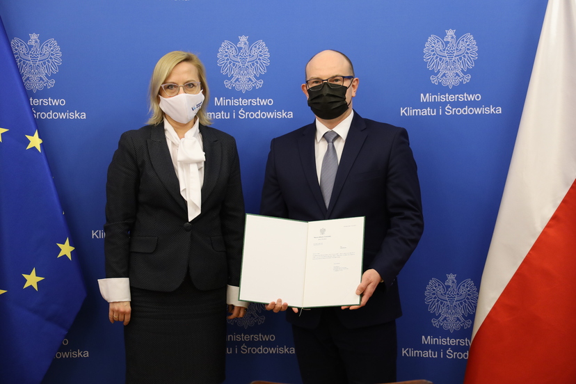 Minister Anna Moskwa oraz marszałek Artur Kosicki trzymający w ręku otwartą teczkę z dokumentem