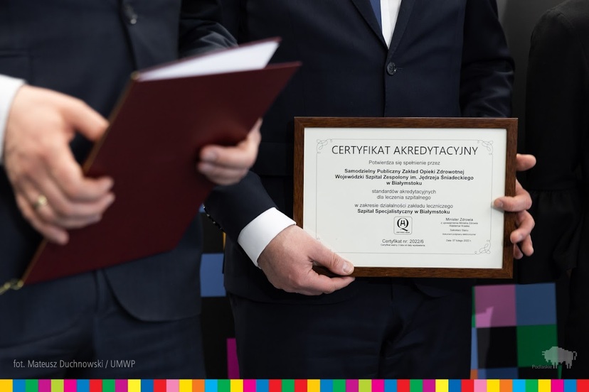 Certyfikat akredytacyjny trzymany w rękach