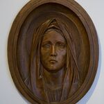twarz kobiety wyrzeźbiona w drewnie