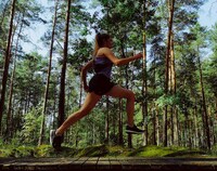 Kobieta w trakcie biegu w lesie.