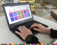 Dłonie leżące na klawiaturze laptopa z wyświetlonym ekranem