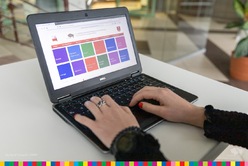 Dłonie leżące na klawiaturze laptopa z wyświetlonym ekranem