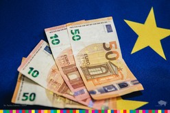 Banknoty euro na tle flagi unijnej