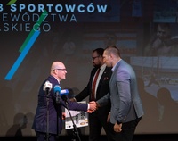 Sportowiec przyjmuje gratulacje z rąk marszałka województwa