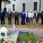 Sekretarz Województwa wraz z uczestnikami wydarzenia stoją przed grobem ks. St. Suchowolca.