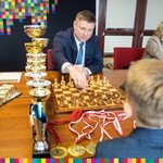 Członek zarządu Marek Malinowski gra w szachy z chłopcem który siedzi tyłem