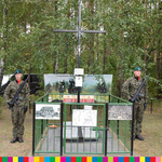 dwóch żołnierzy stojących obok krzyża