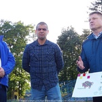 Marek Malinowski trzyma w ręku czek, dwóch mężczyzn stoi obok.