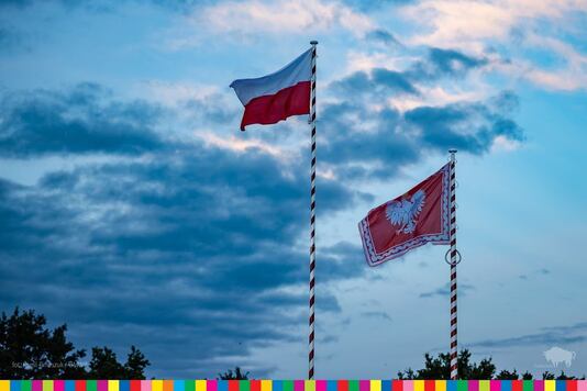 Na biało-czerwonych masztach widoczne flaga Polski oraz sztandar Prezydenta RP
